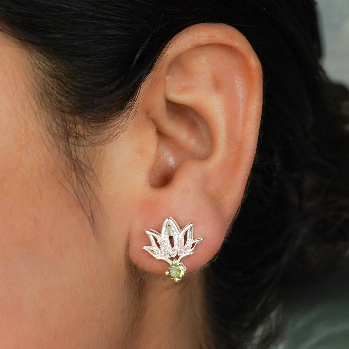 Silver CZ Lotus Earring worn on ear with pink and green accents