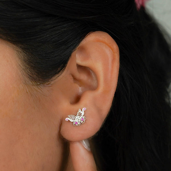Close-up of butterfly stud earrings on ear