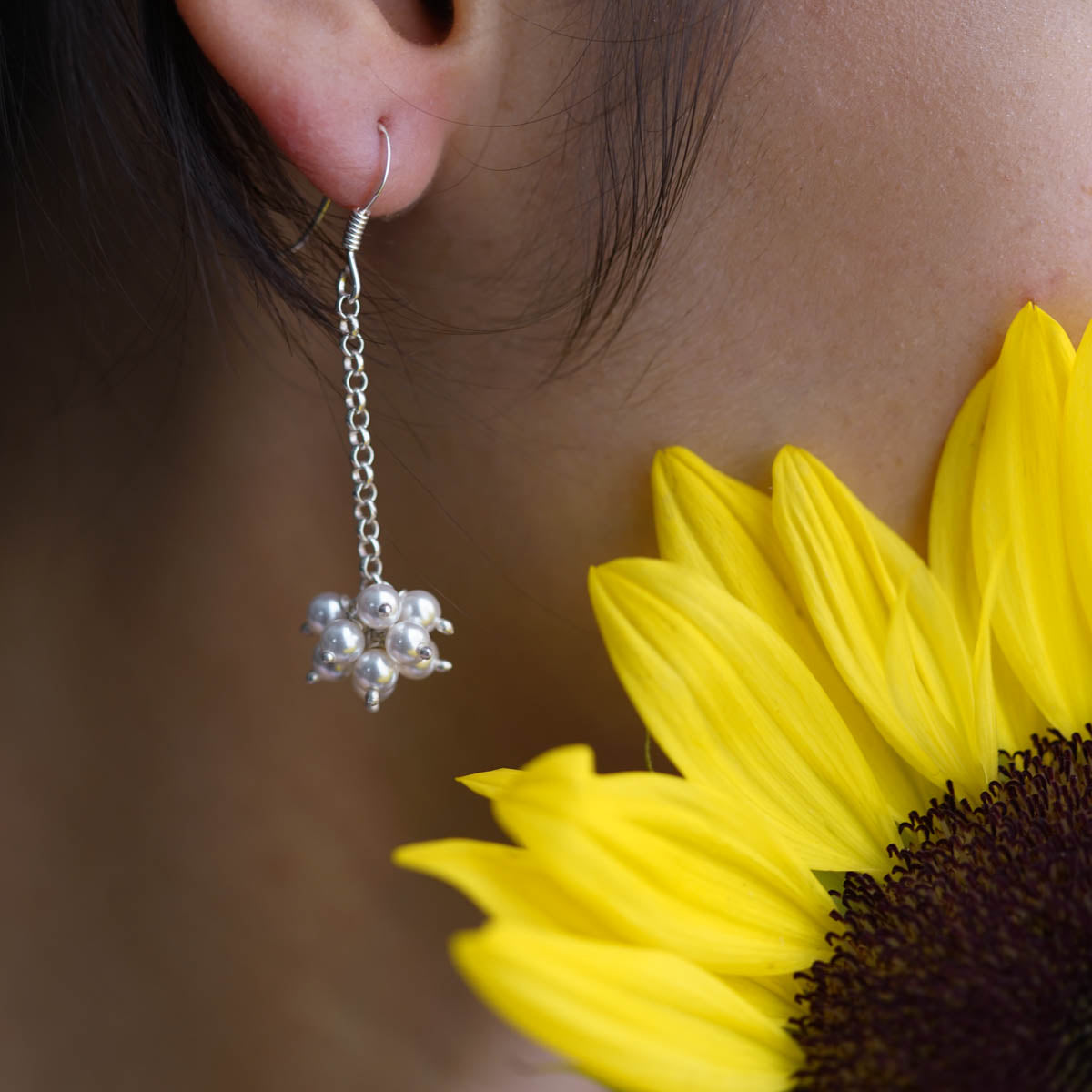 a close up of a person wearing a pair of earrings