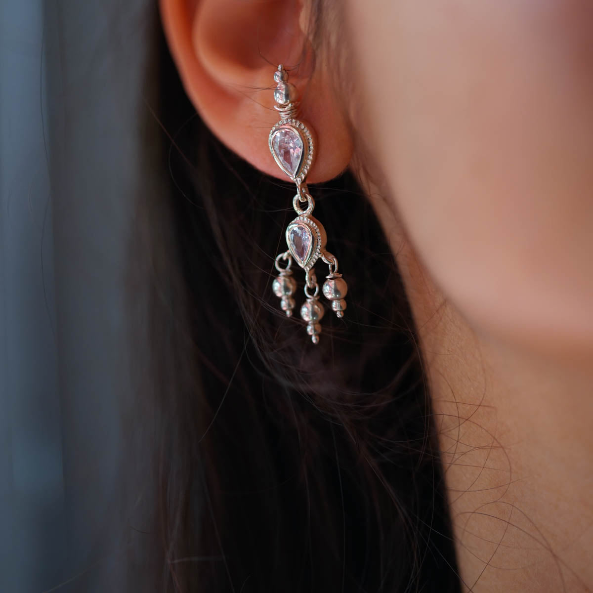 a close up of a person wearing a pair of earrings