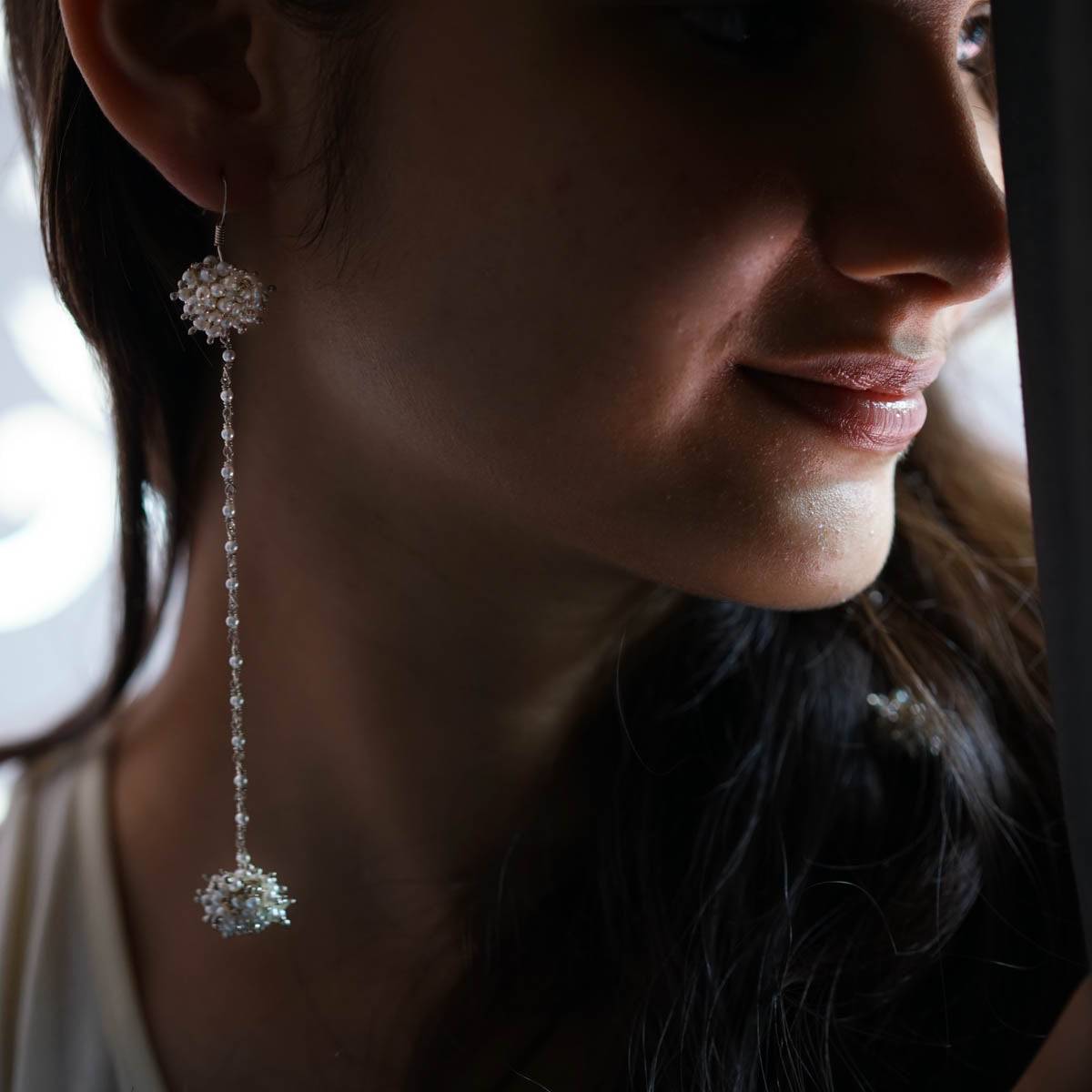 a close up of a person wearing a pair of earrings