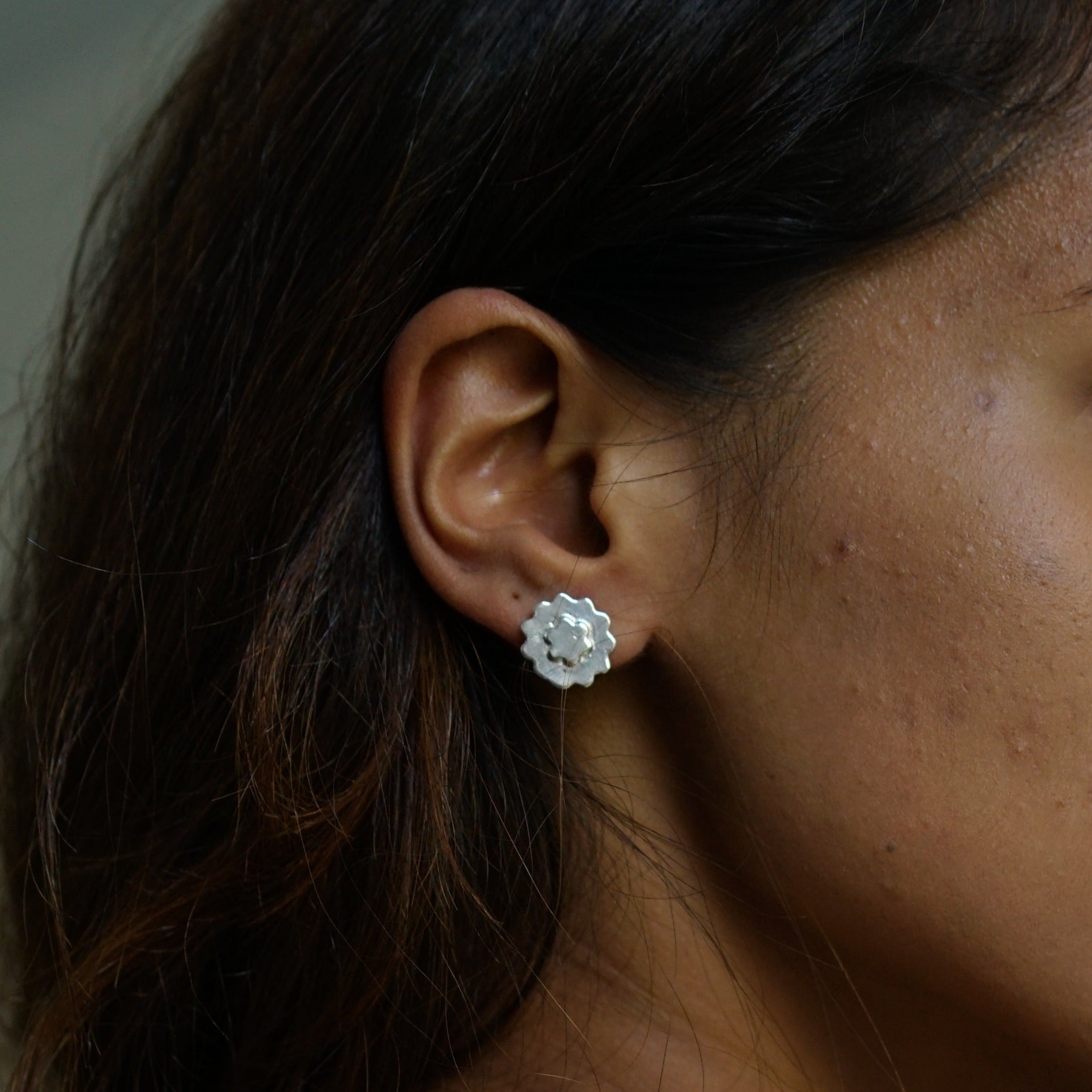 a close up of a person wearing a pair of earrings