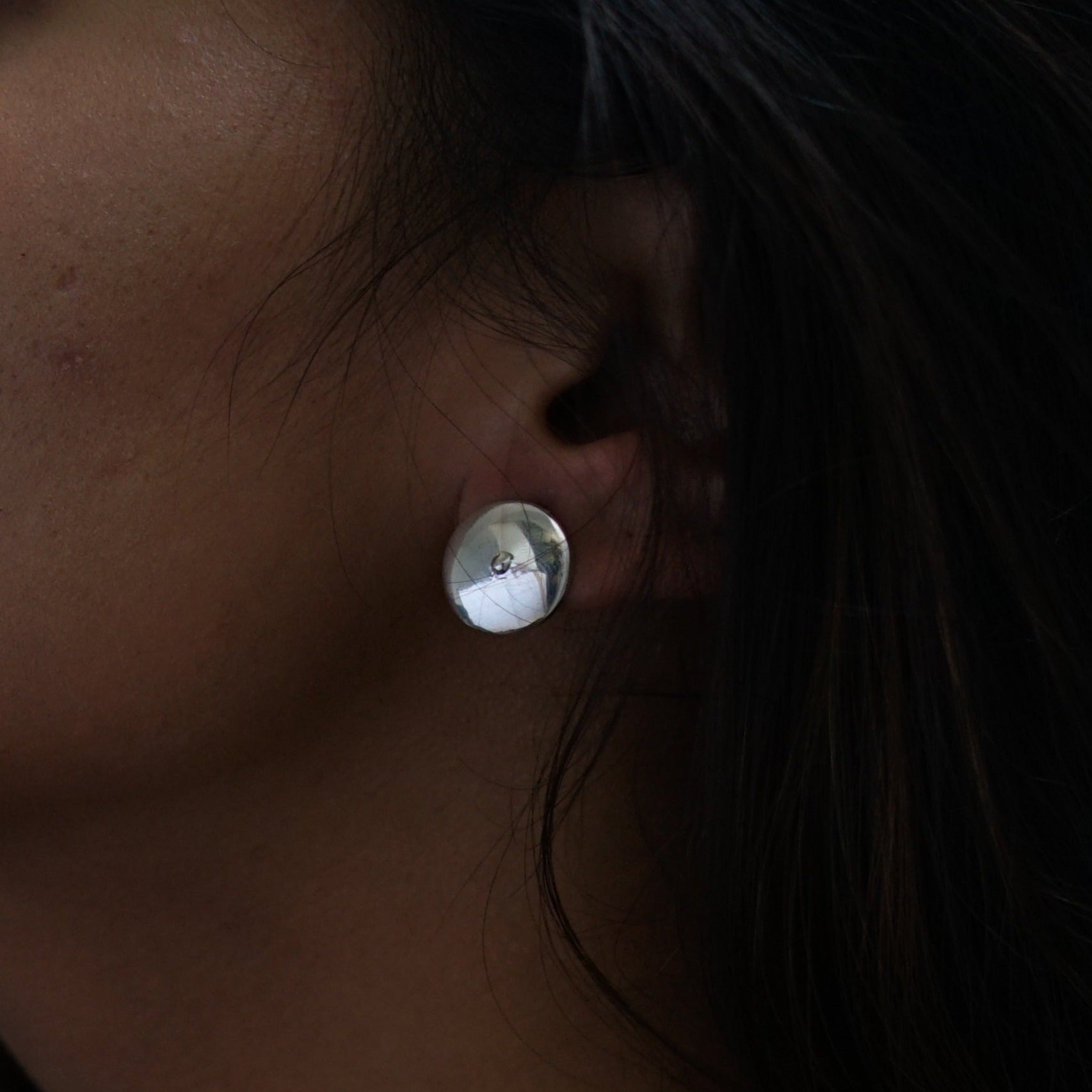 a close up of a person wearing a pair of earrings