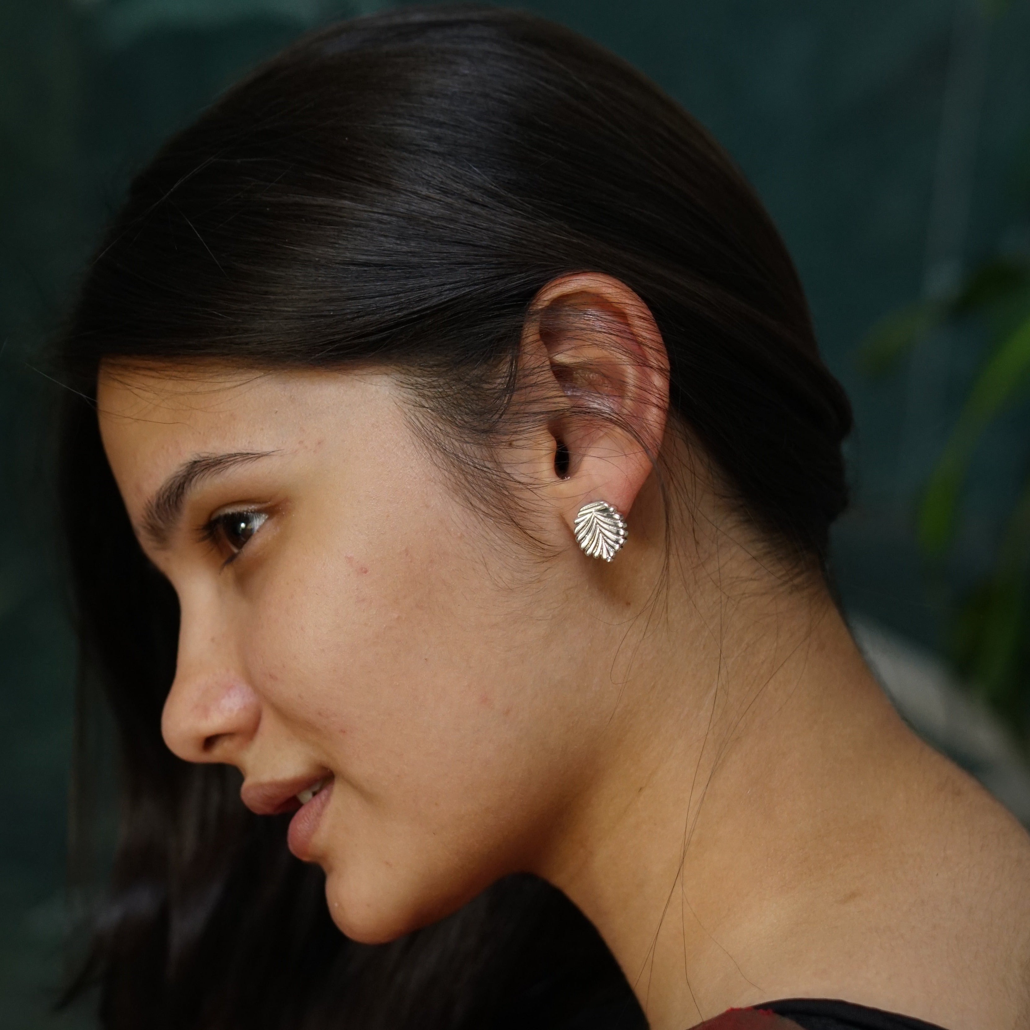 a close up of a person wearing a pair of earrings