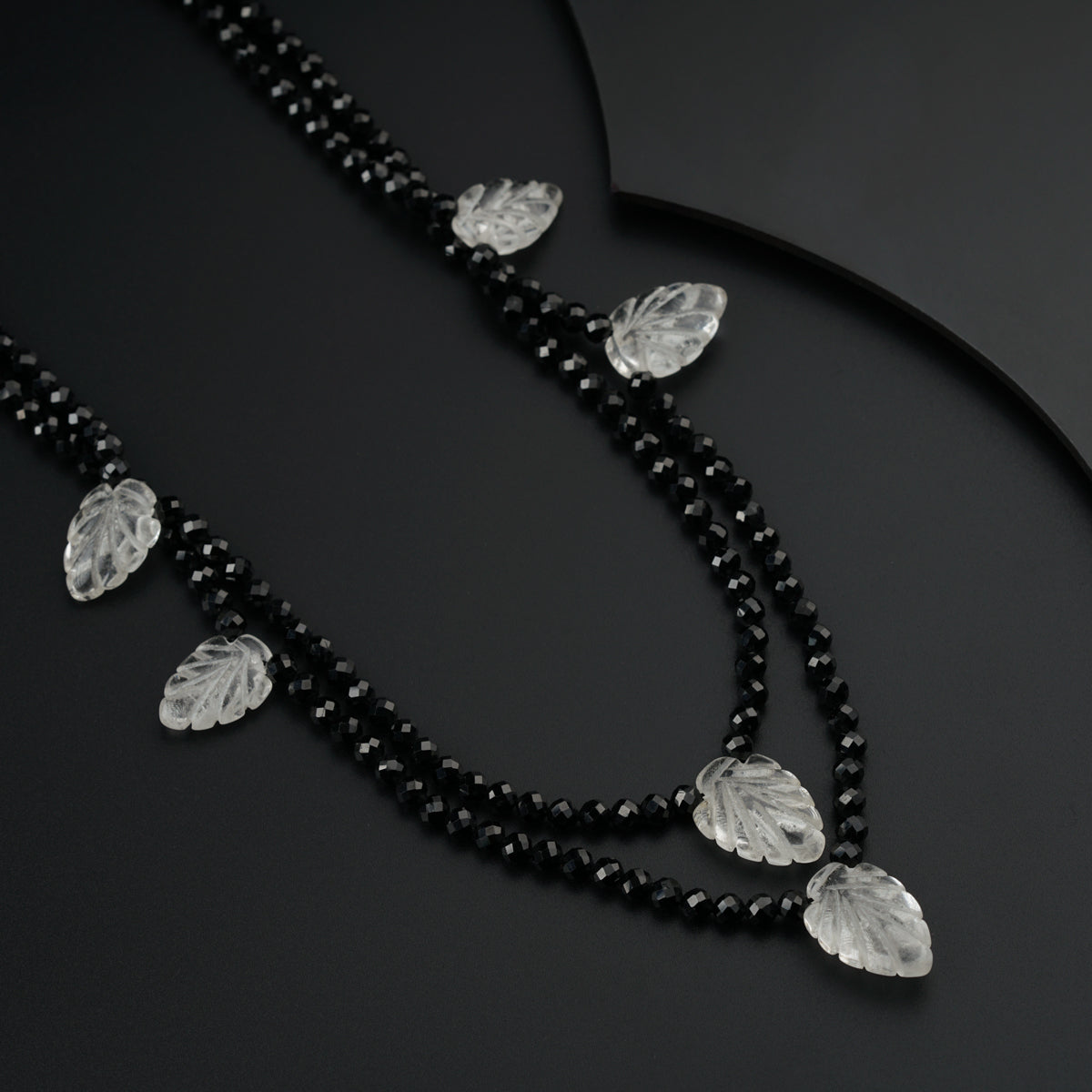 a black beaded necklace with leaf charms