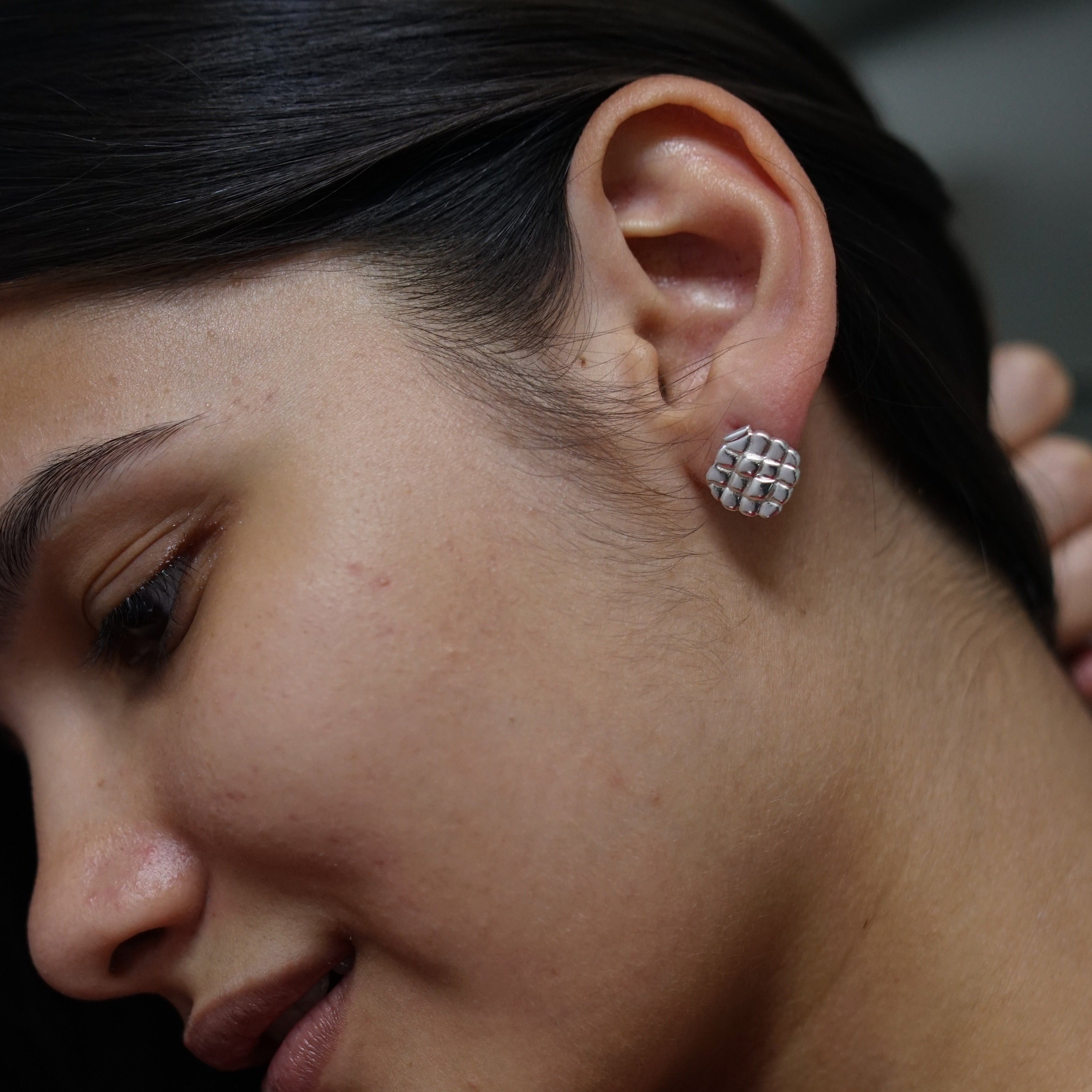 a close up of a person wearing a pair of earrings