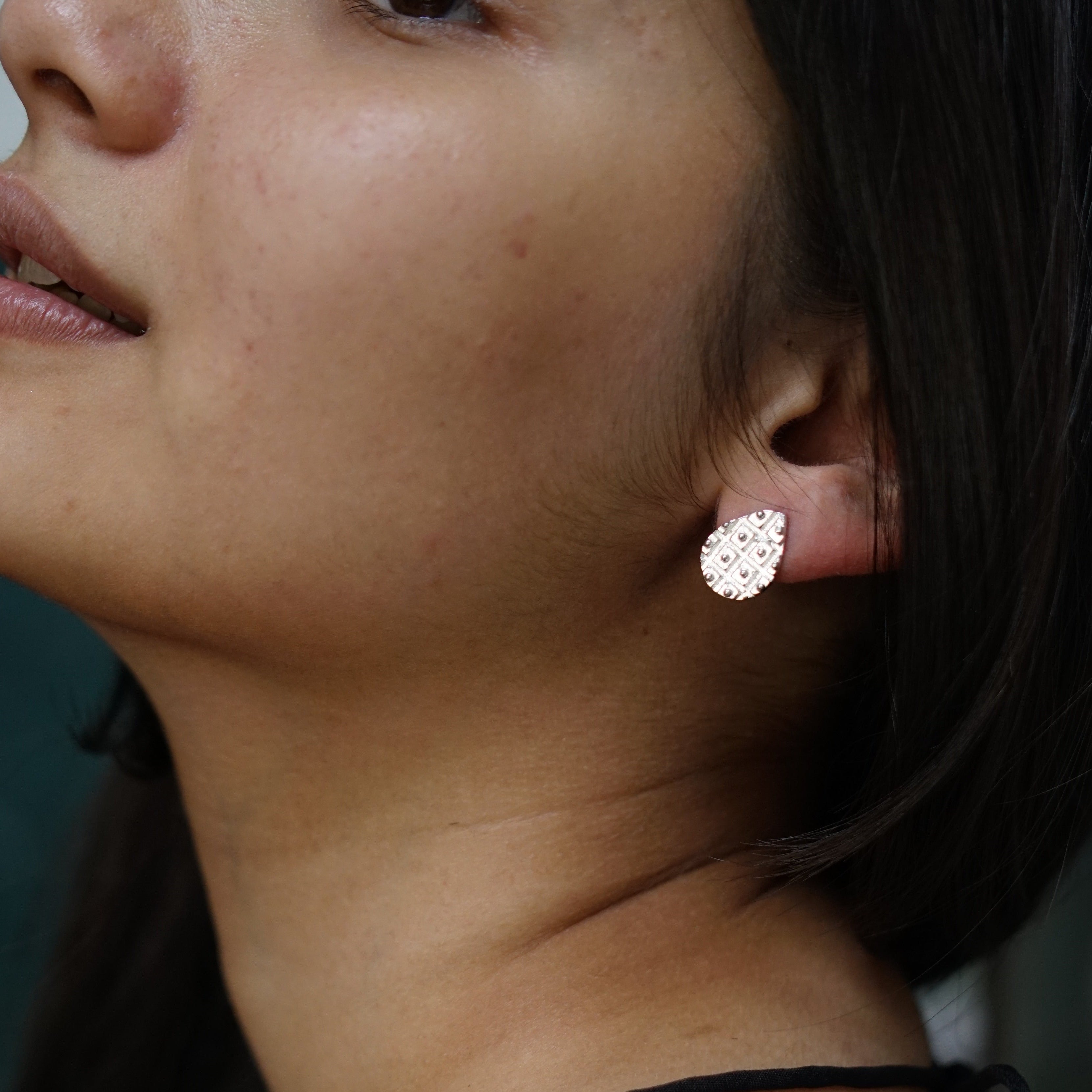 a close up of a person wearing a pair of earrings