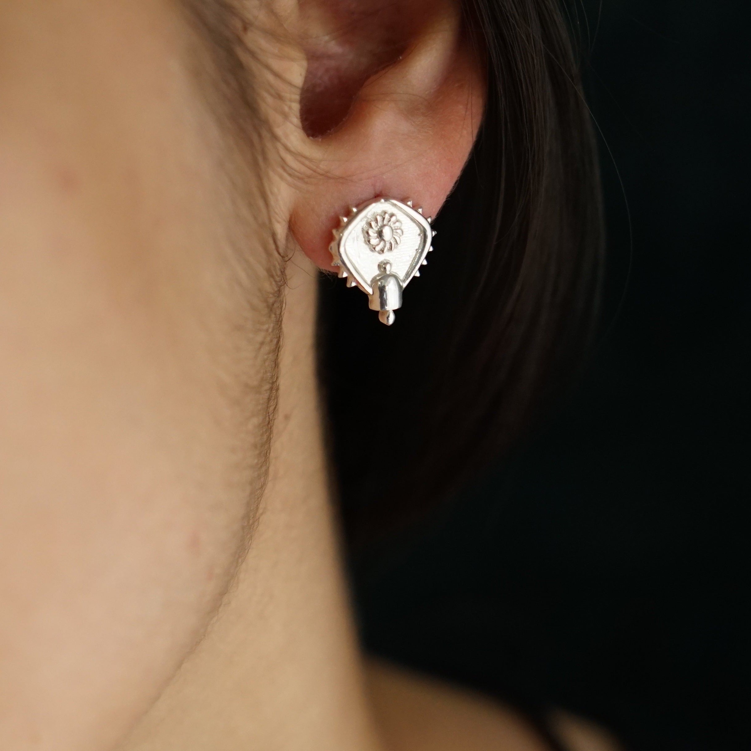 a close up of a person wearing a pair of earrings