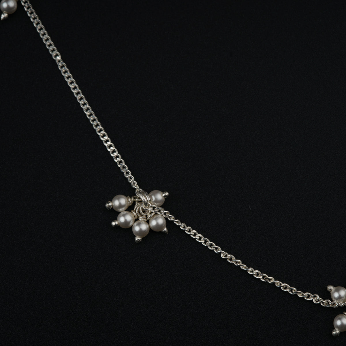 a close up of a necklace with pearls