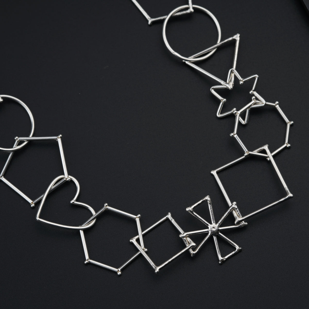 a necklace made of silver wire on a black surface