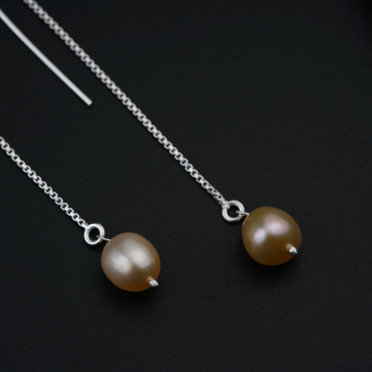a pair of brown pearls on a silver chain