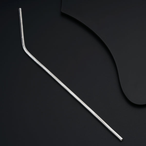 a pair of metal straws sitting on top of a black surface