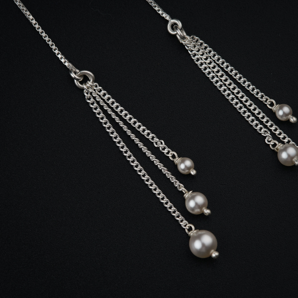 a close up of a pair of pearls on a chain