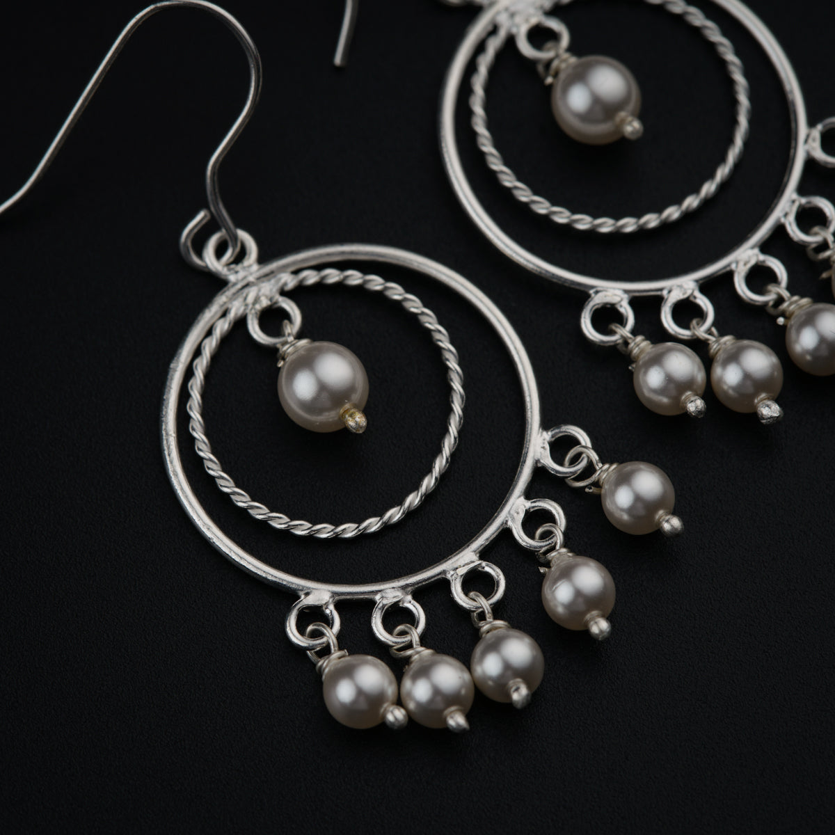 a pair of silver hoop earrings with pearls