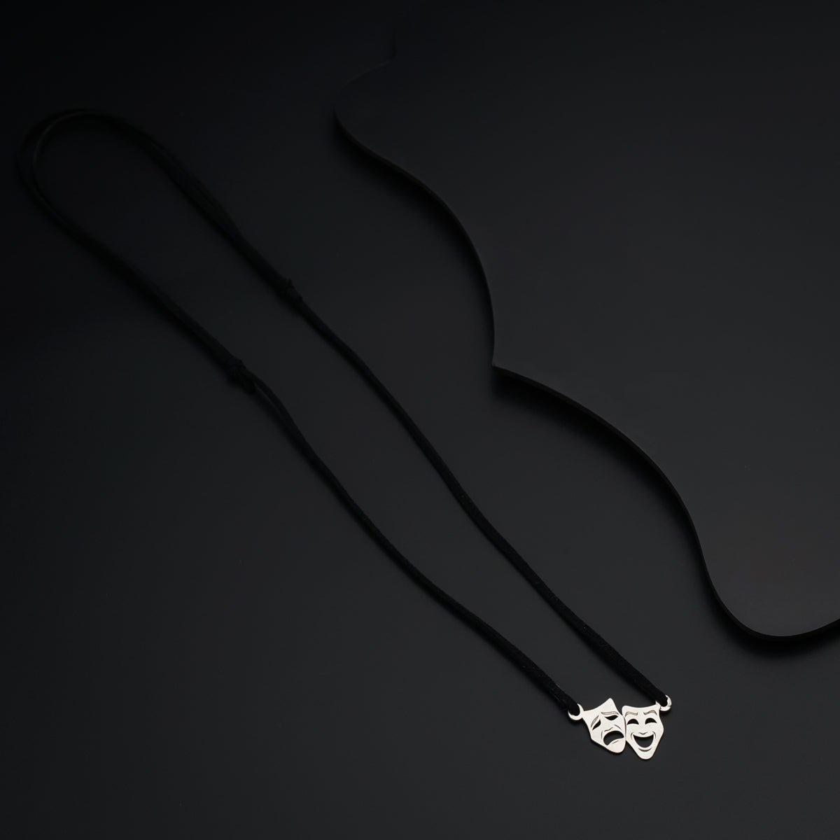 a necklace with a mask hanging from it