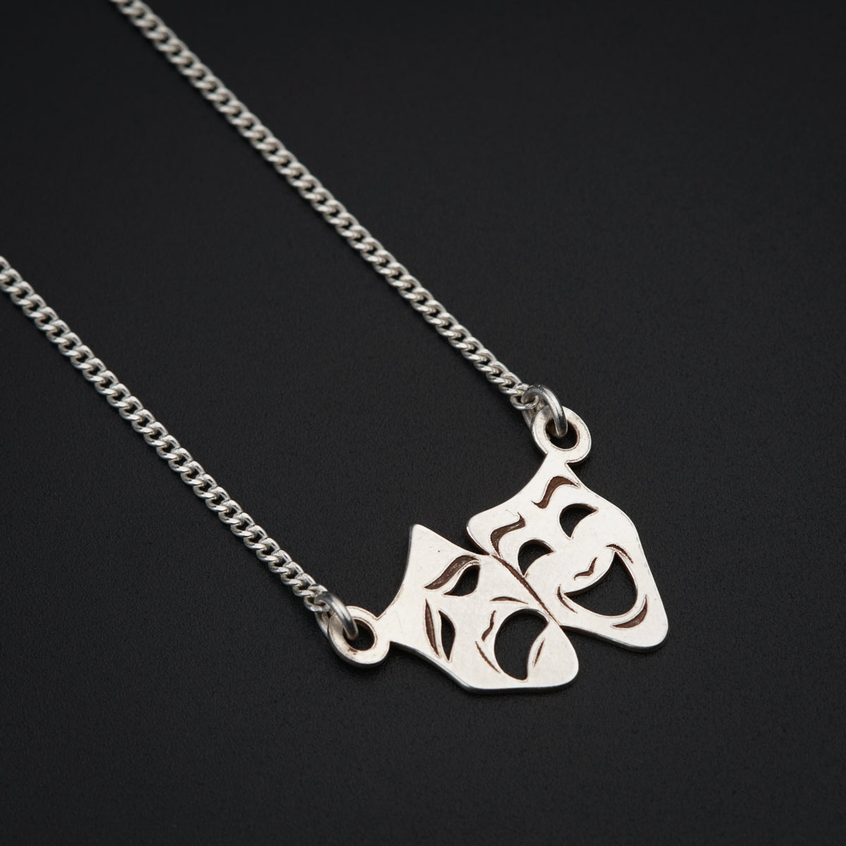 two pieces of silver metal on a chain