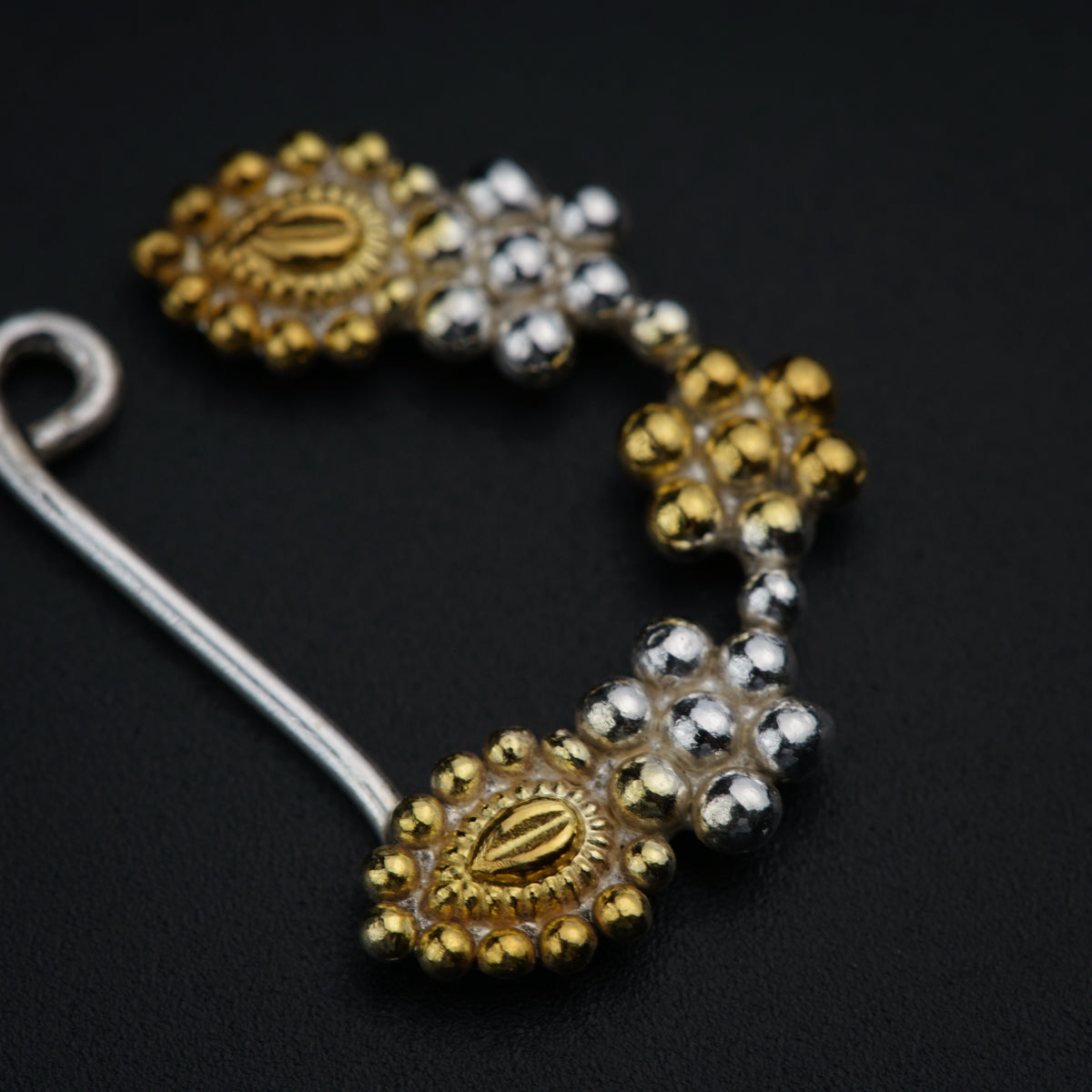 a close up of a pair of earrings on a black surface