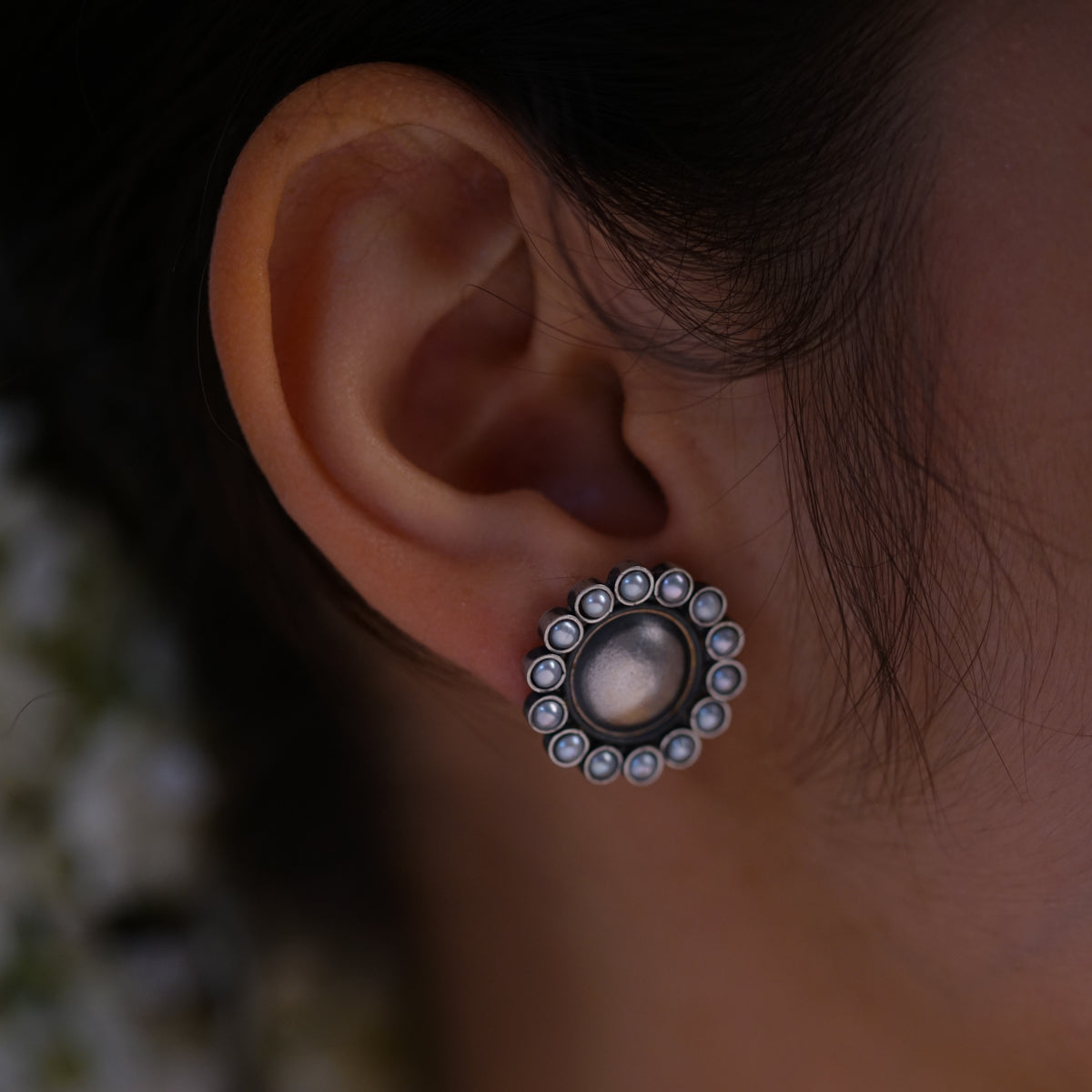 a close up of a person wearing a pair of earrings
