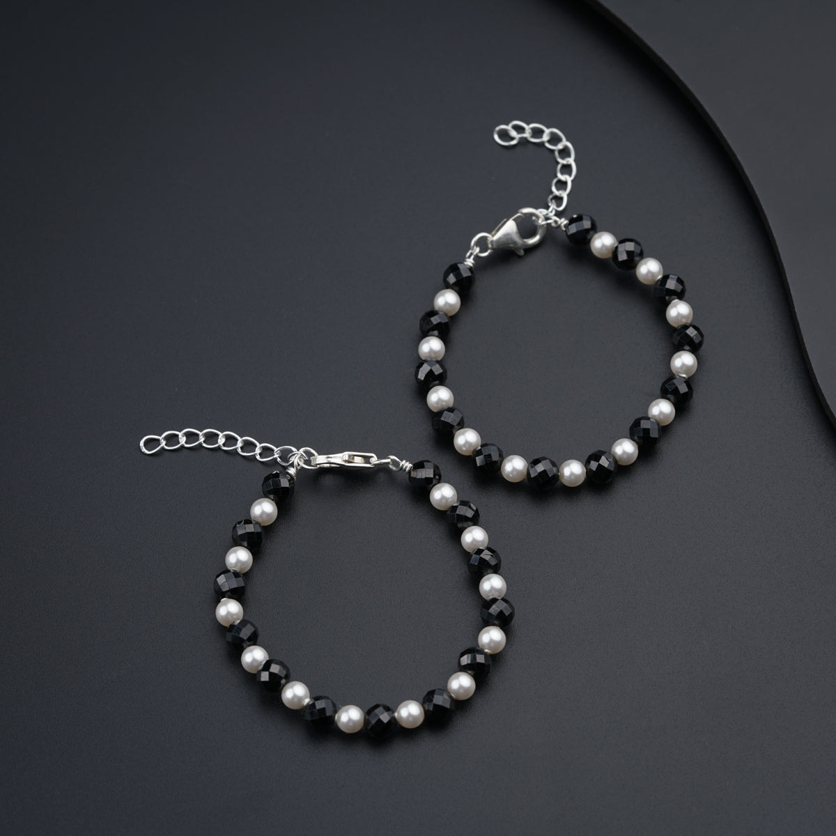 a pair of black and white beaded bracelets