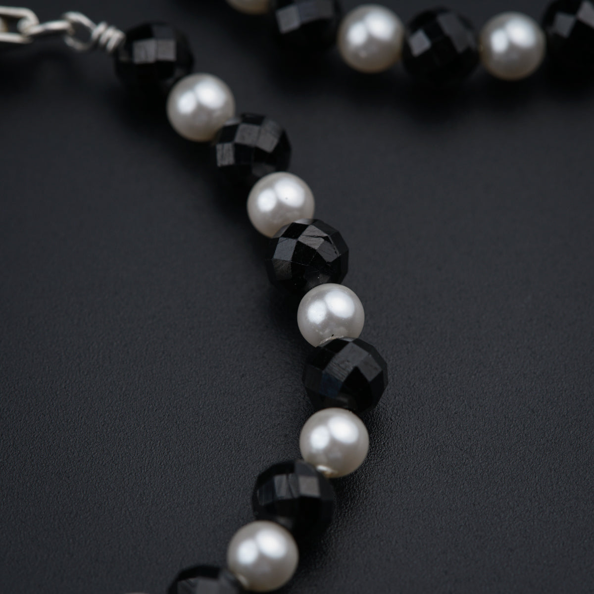 a close up of a necklace with pearls