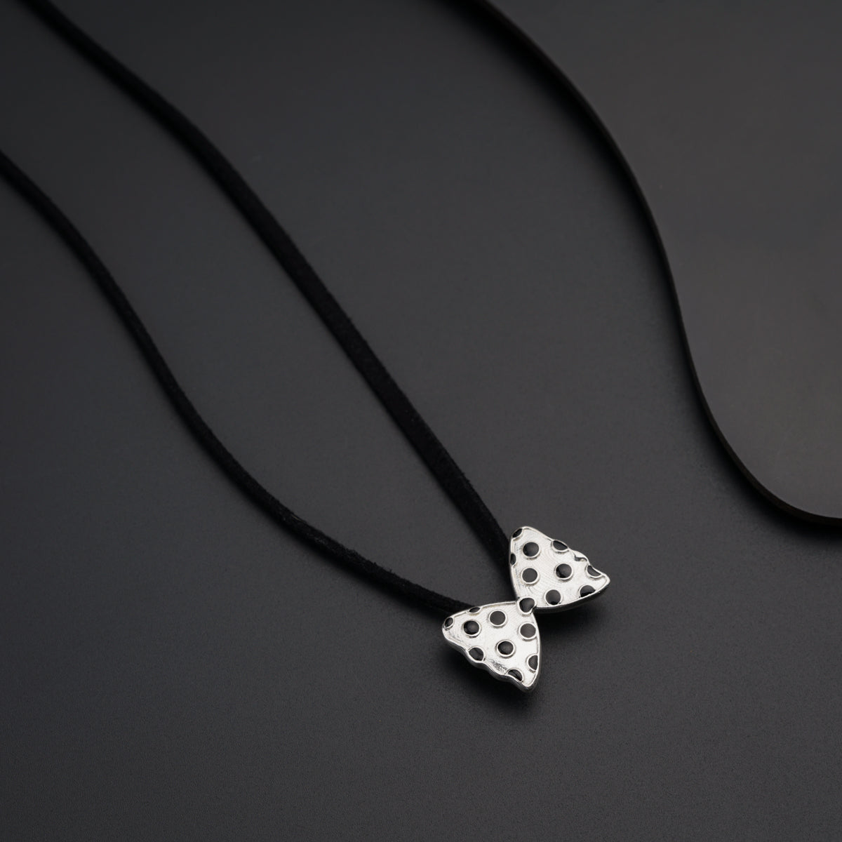 a black and white necklace with two white polka dots on it