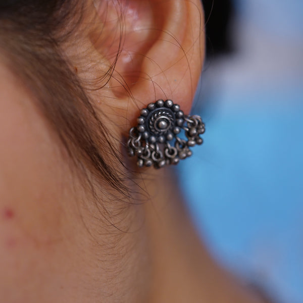 a close up of a person wearing a pair of earrings