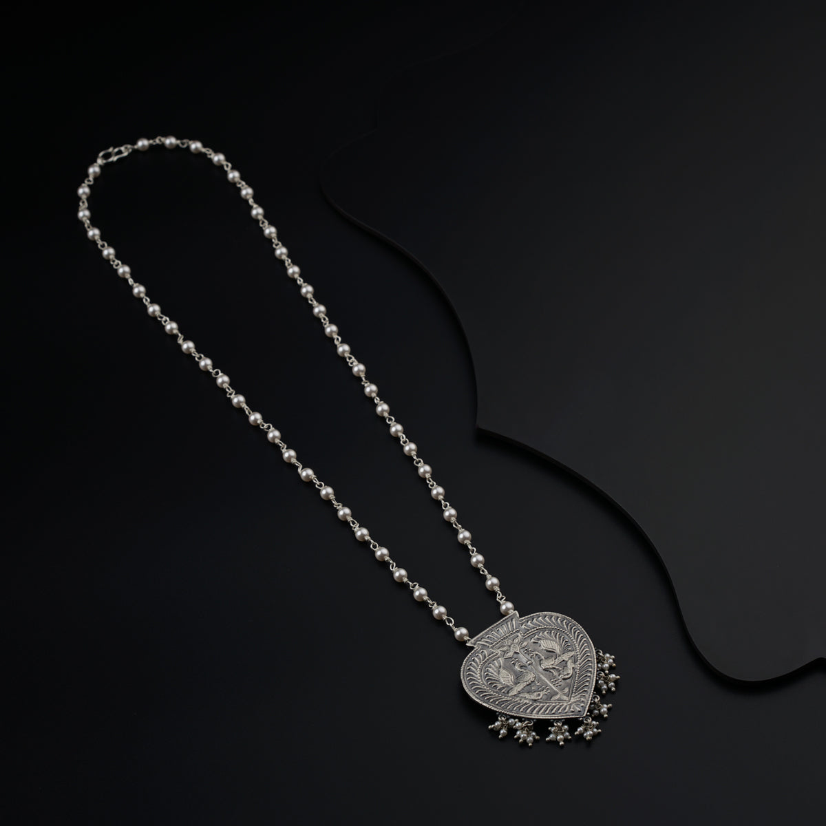 a necklace with a heart shaped pendant on a chain