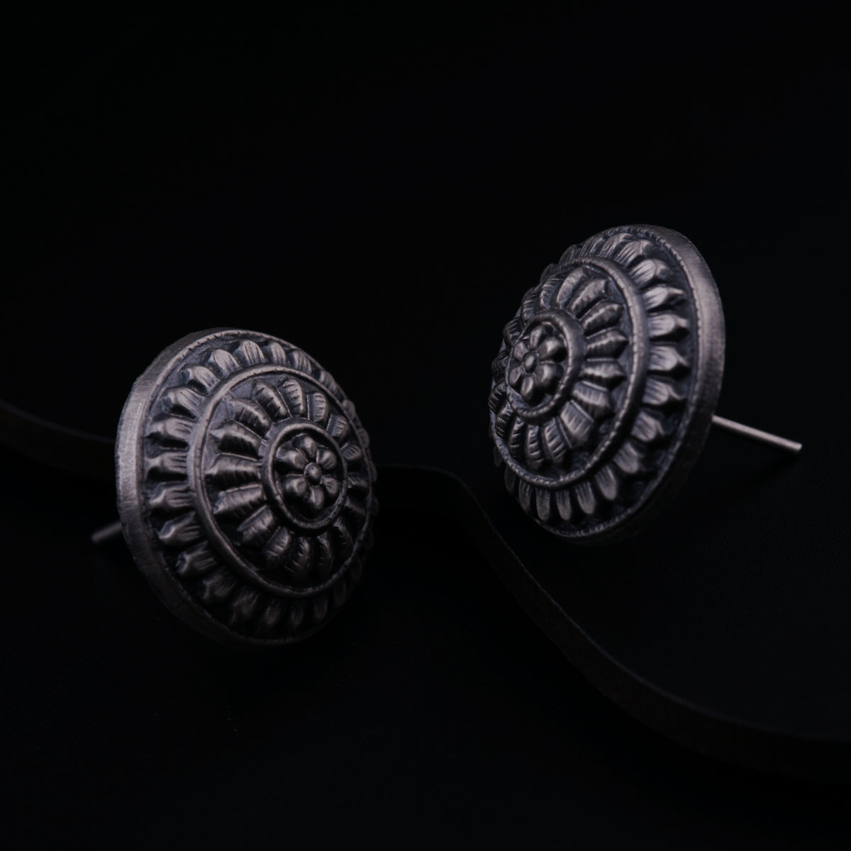 a pair of earrings on a black background