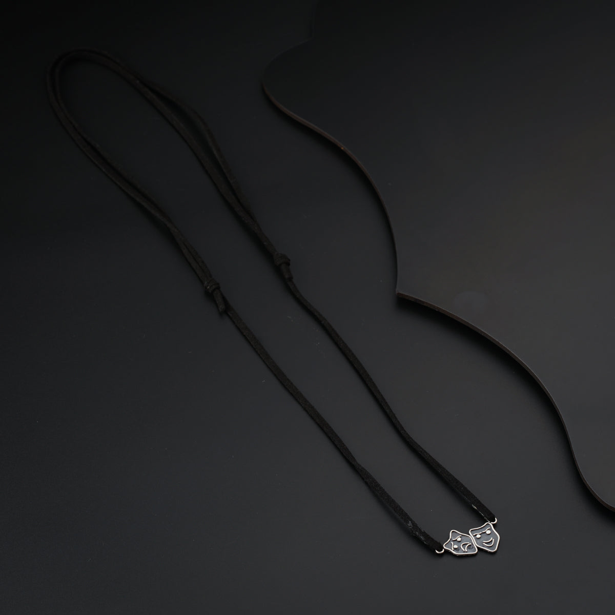a necklace with a bow on a black background