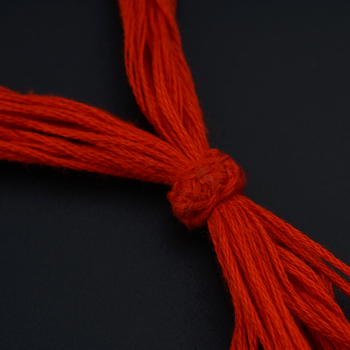 a close up of a red string on a black surface