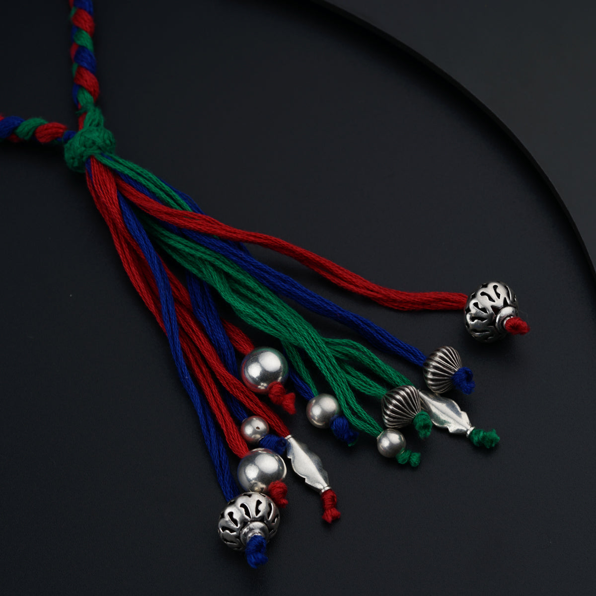 a red, blue, and green cord with bells on it