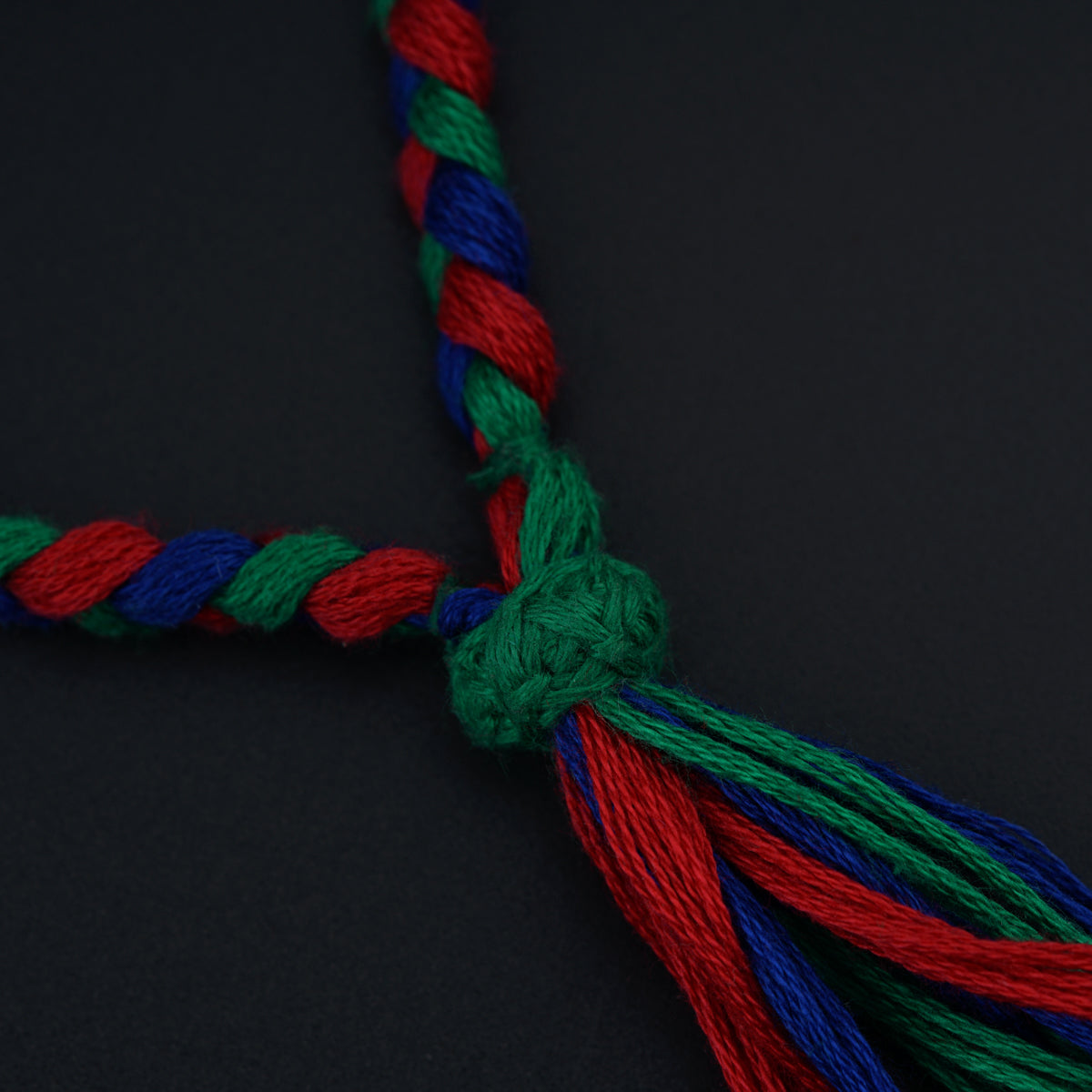 a red, green, and blue rope on a black surface