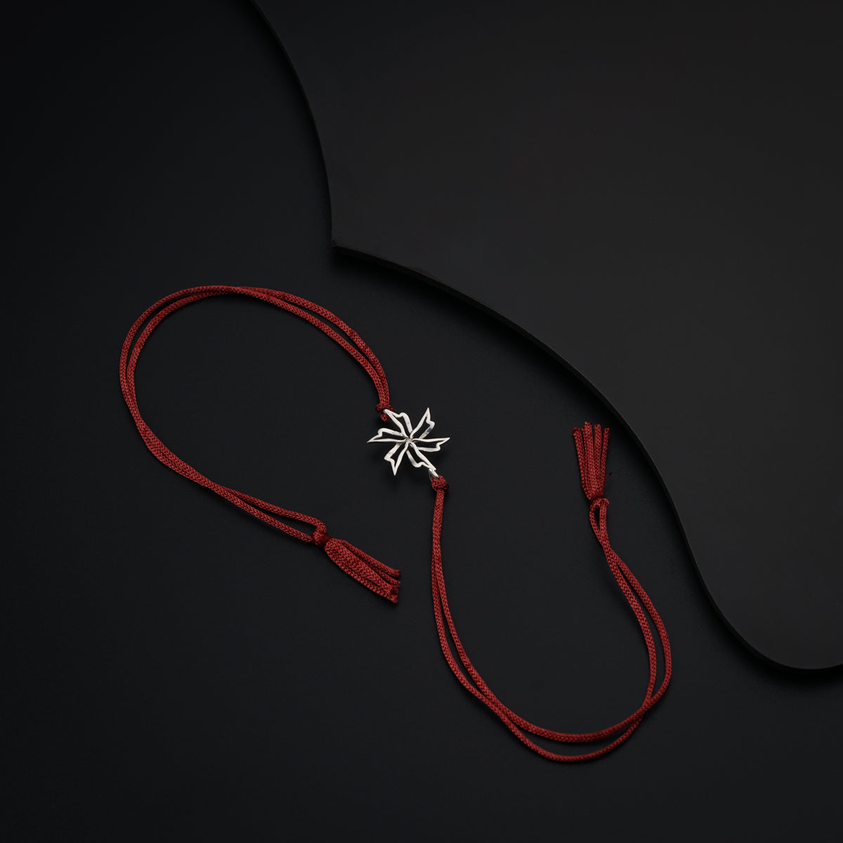 a red cord with a silver cross on it