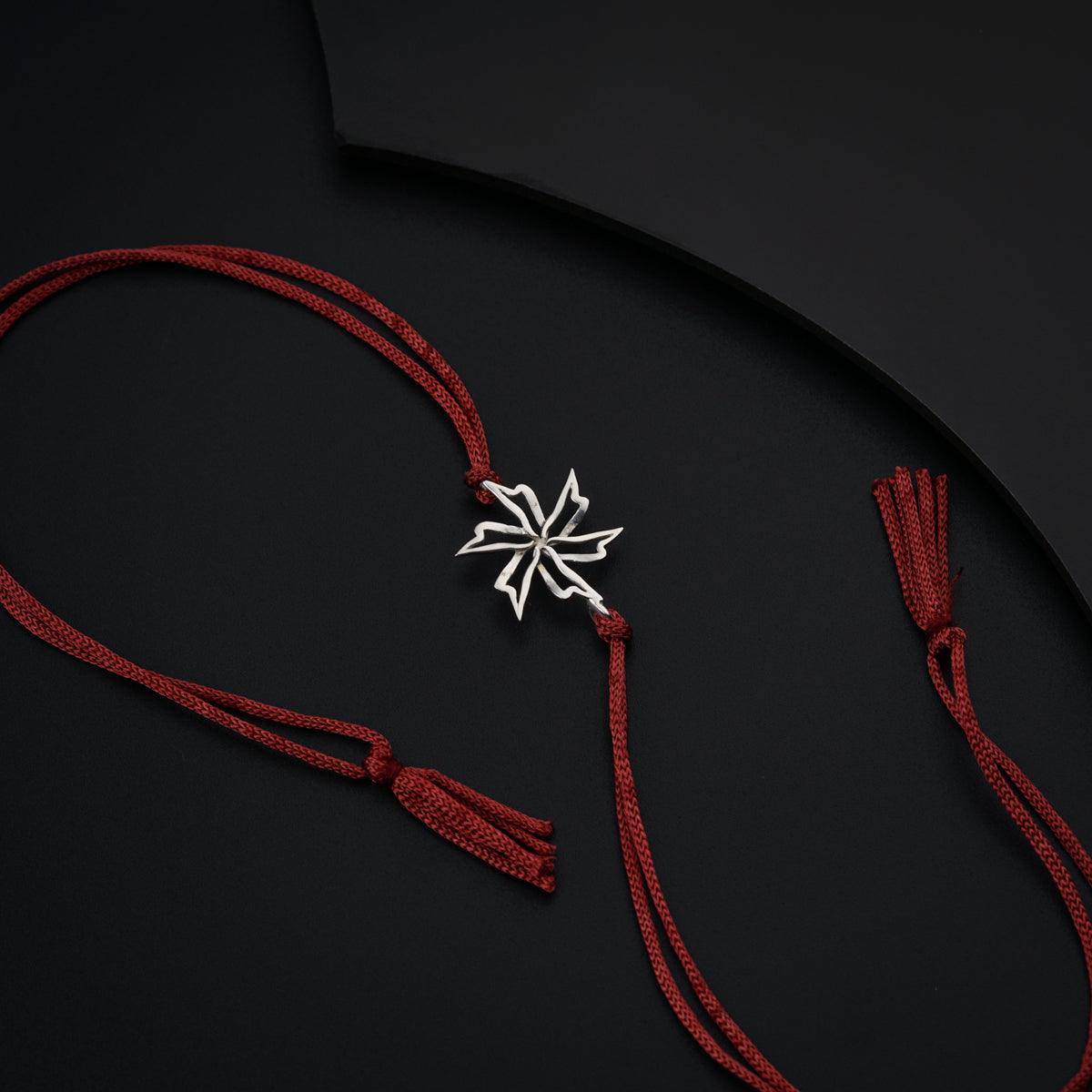 a red string with a silver snowflake on it
