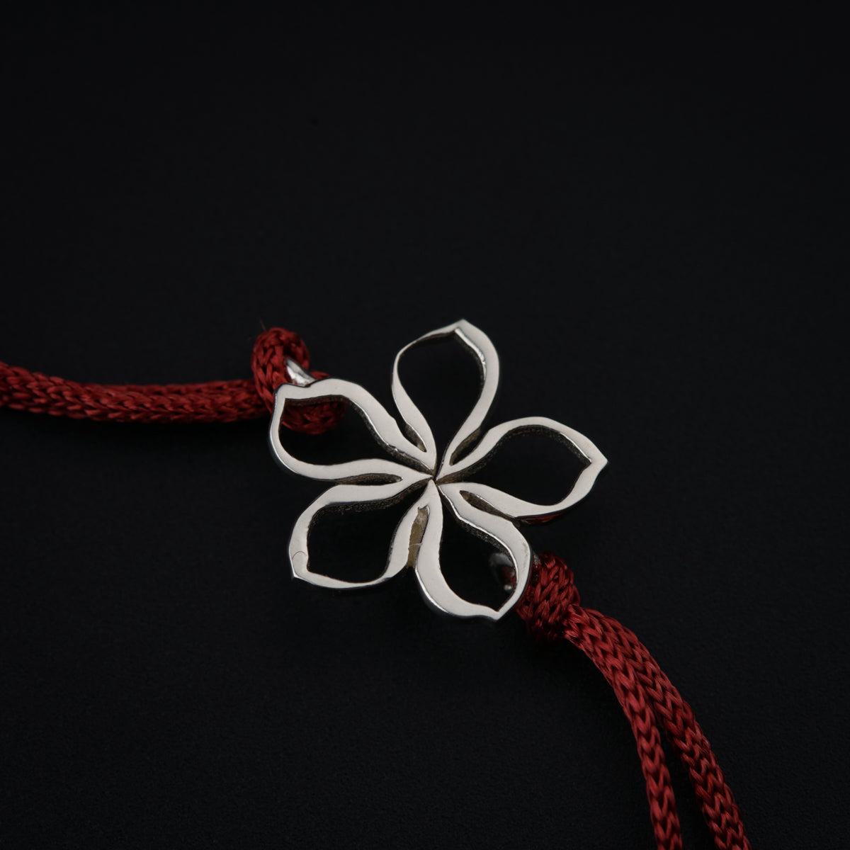 a red rope with a white flower on it