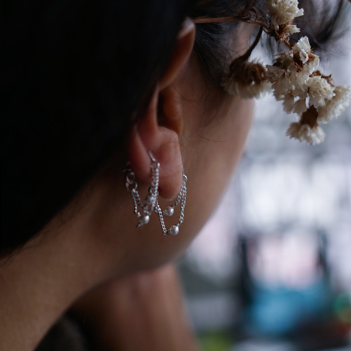 a close up of a person wearing a pair of earrings