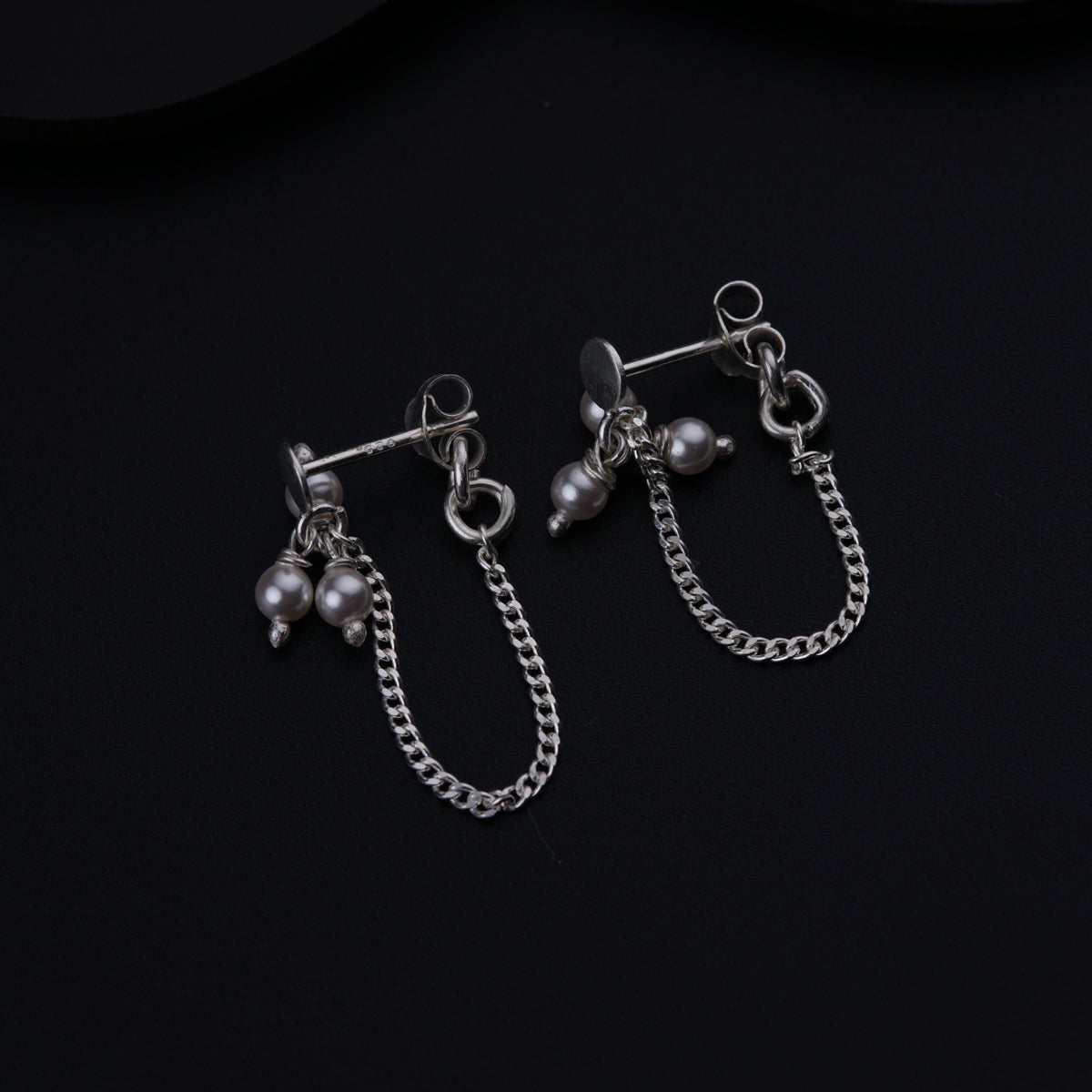 a pair of earrings on a black surface