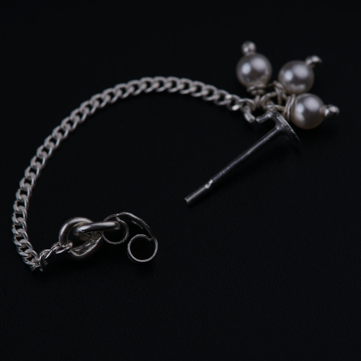 a pair of scissors and a chain on a black surface