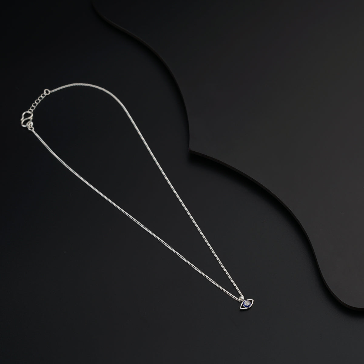 a necklace with a heart on a black background