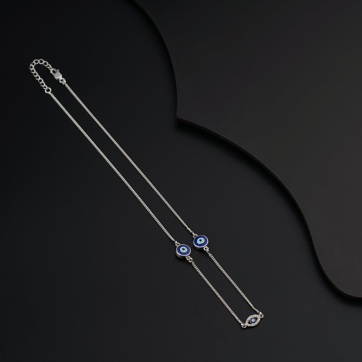 a pair of evil eye necklaces on a black background