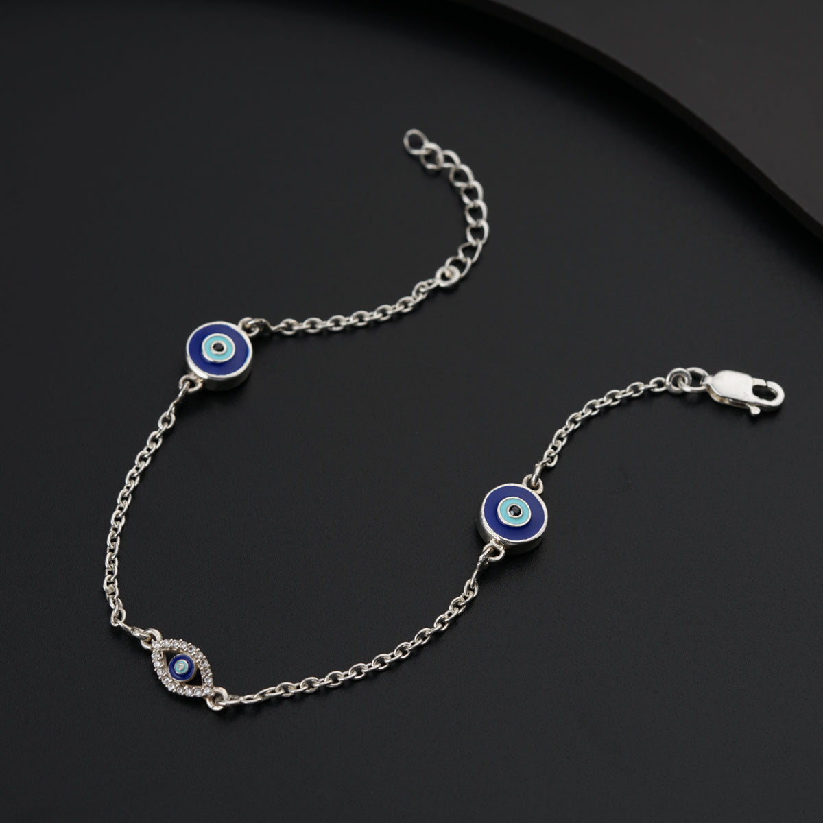a blue evil eye bracelet on a black surface