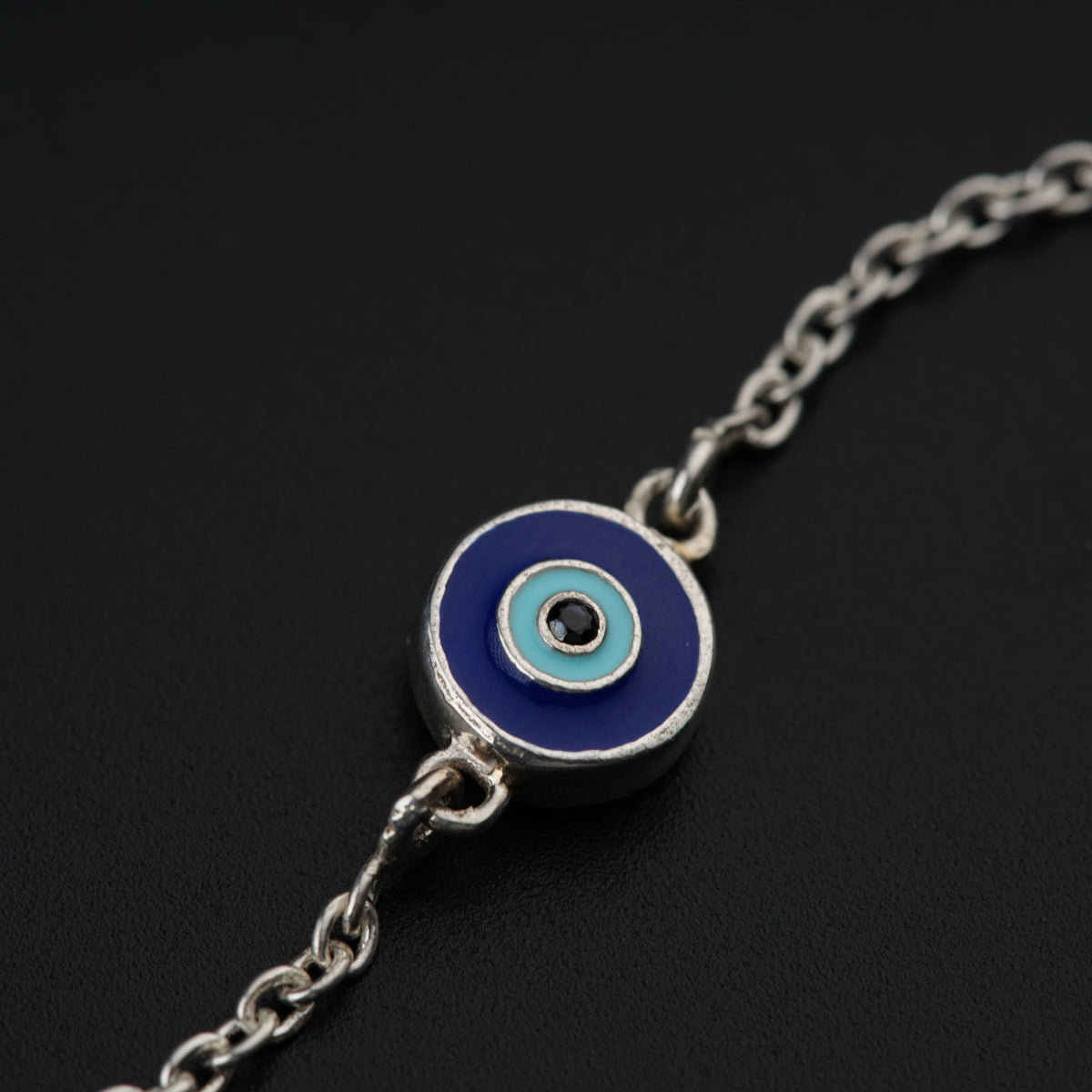 a blue evil eye charm on a silver chain