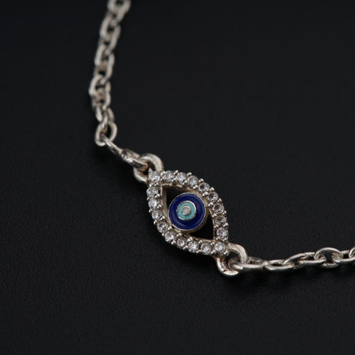a silver chain with a blue evil eye on it