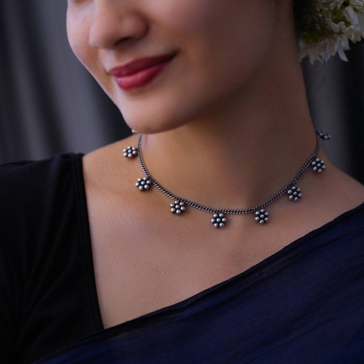 a close up of a woman wearing a necklace