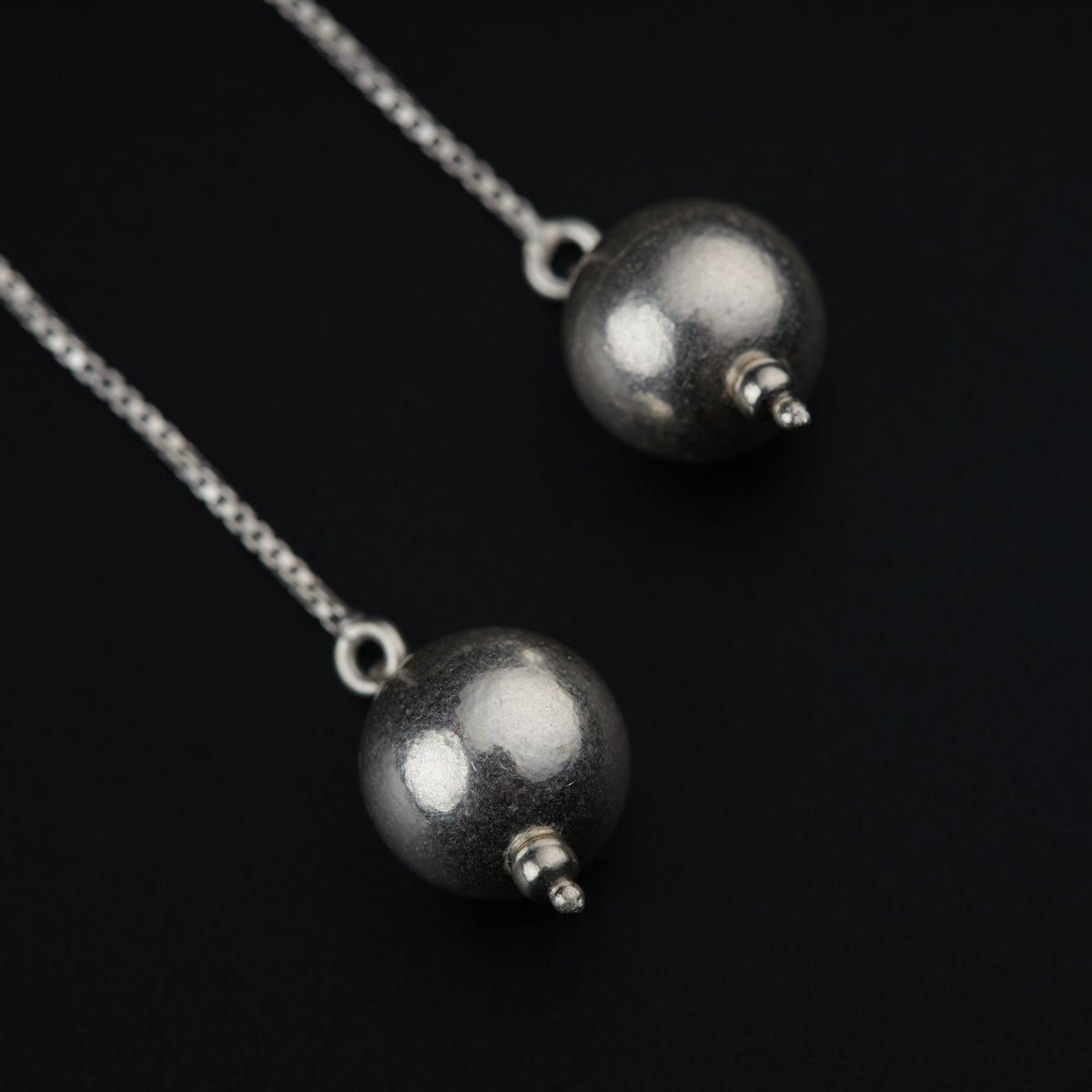 a pair of silver balls on a chain