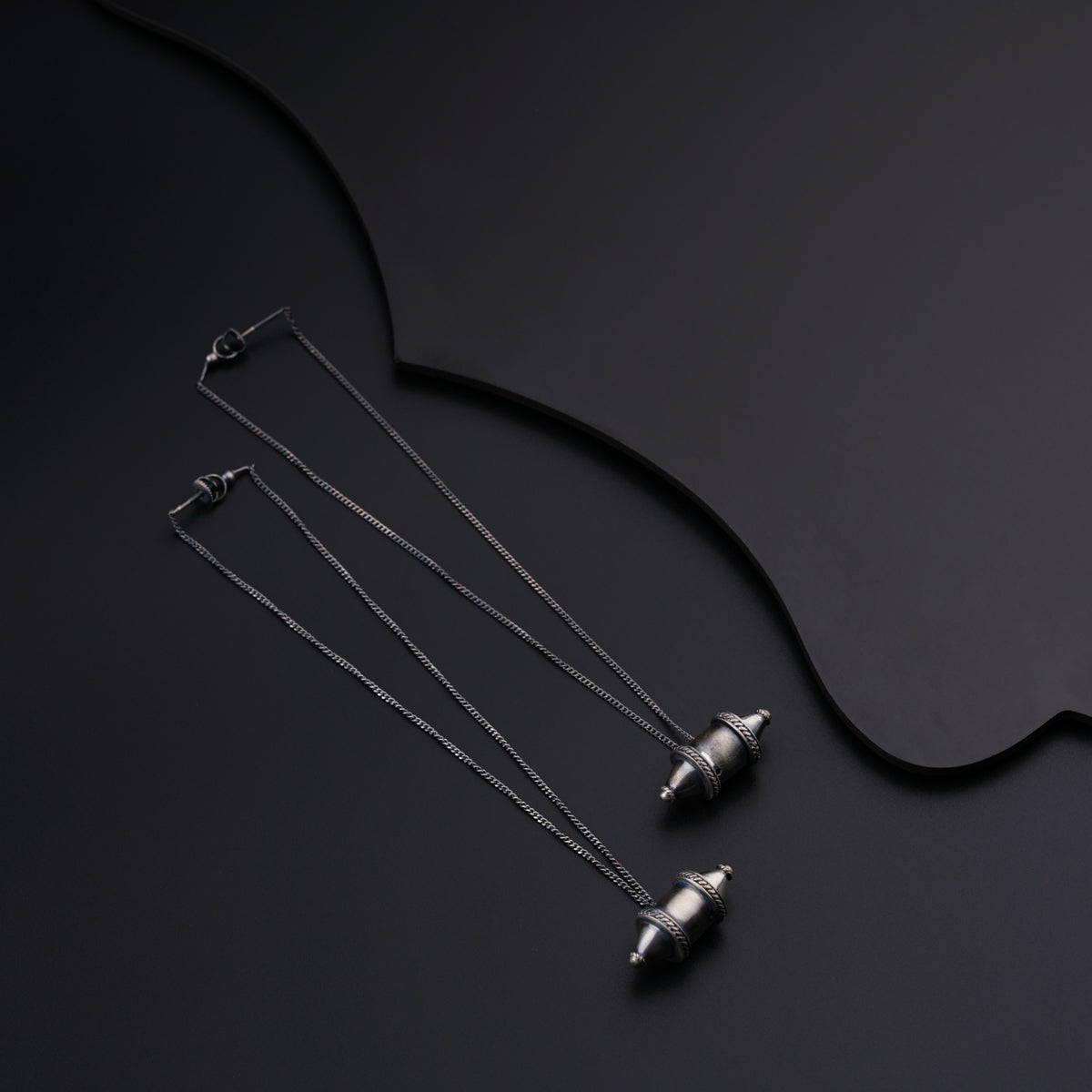 a set of three necklaces on a black surface