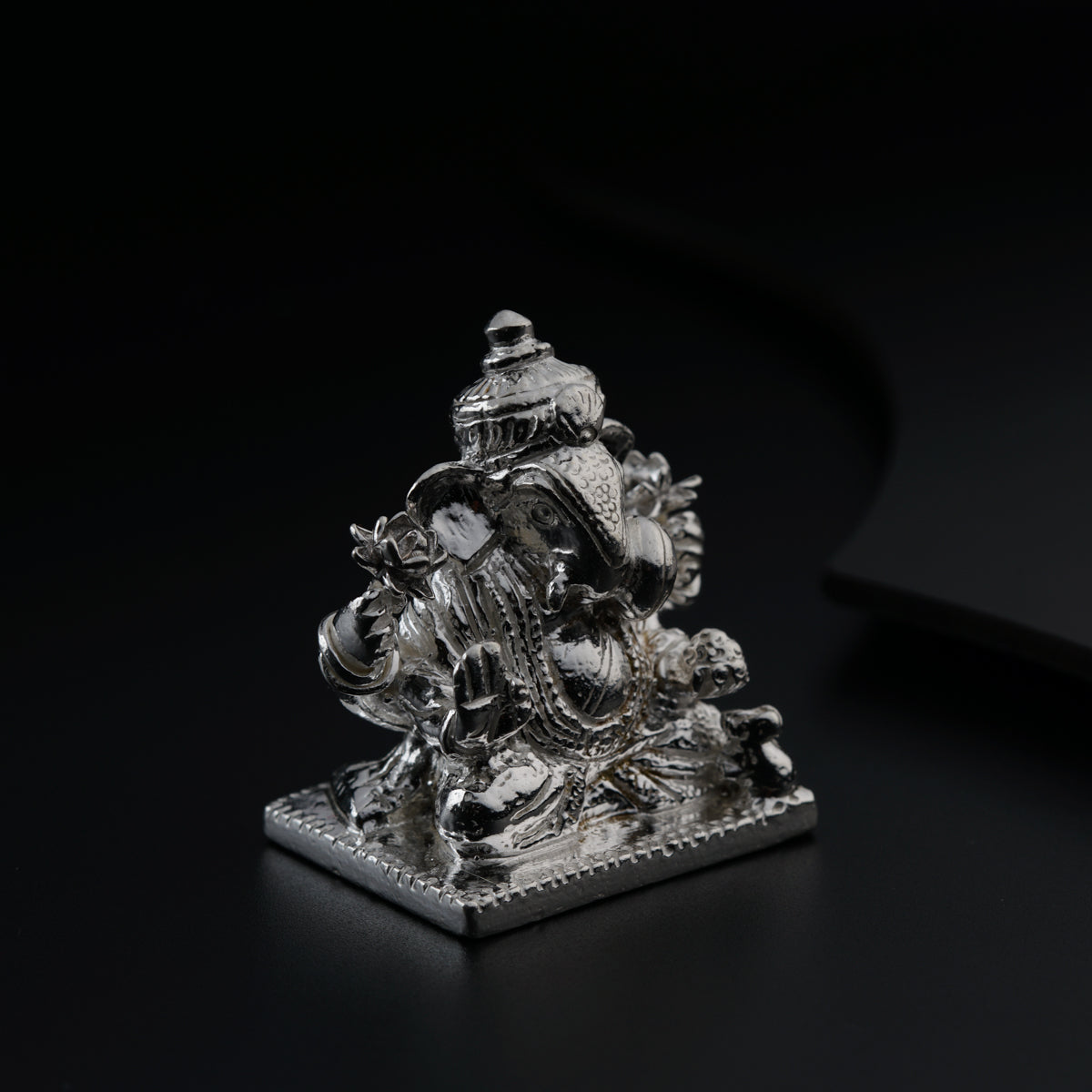 a silver statue sitting on top of a black table