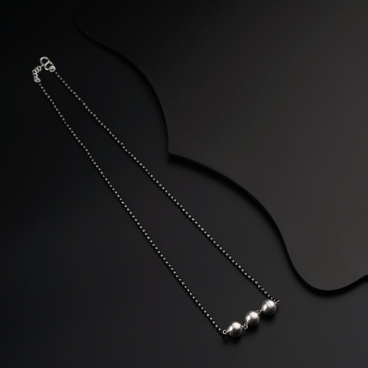 a pair of necklaces on a black surface