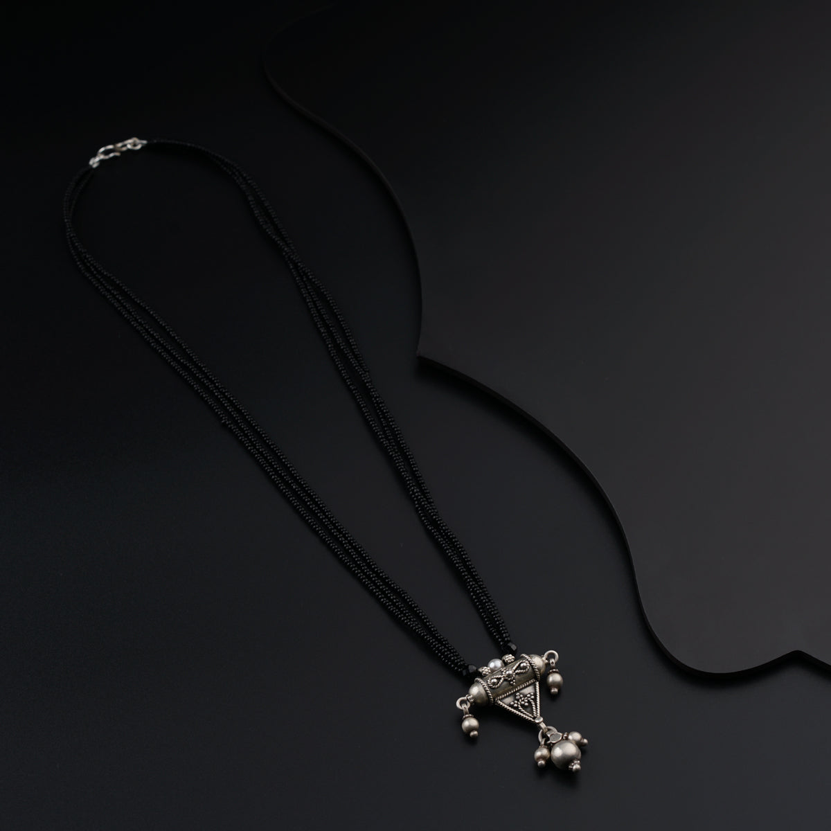 a black necklace with a cross on it