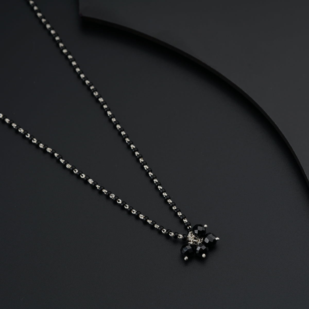 a necklace with a cross on a black background